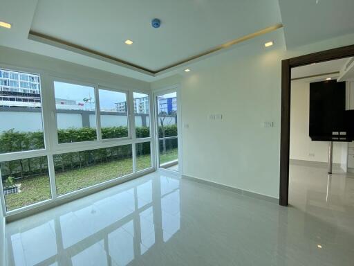 Spacious and brightly lit living room with a large window and glossy floor