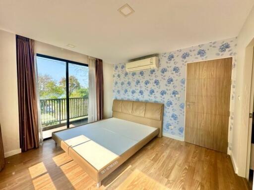 Spacious bedroom with modern decor, natural light, and balcony access