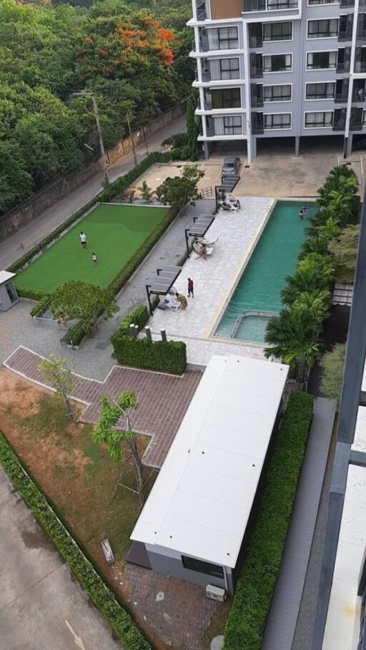 Aerial view of residential building with pool and green space