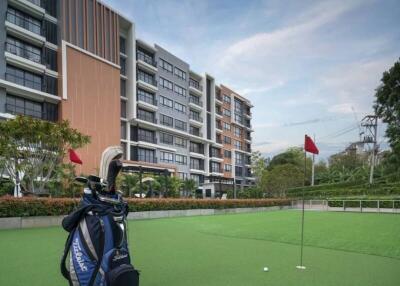 Golf bag on green with residential building background