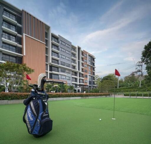 Golf bag on green with residential building background