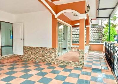 Spacious tiled balcony with ornate railing and a large glass door