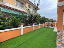 Well-maintained house exterior with artificial grass and colorful design