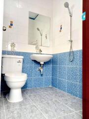 Bright bathroom with blue tiles, modern toilet, and shower