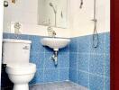 Bright bathroom with blue tiles, modern toilet, and shower