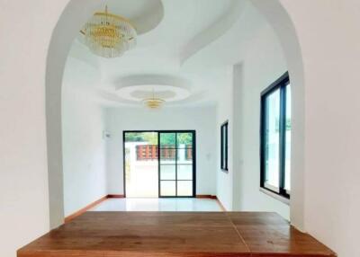 Spacious living room with hardwood floors and arched entryway