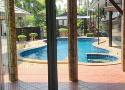 View of a backyard with swimming pool through sliding glass doors