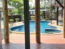 View of a backyard with swimming pool through sliding glass doors