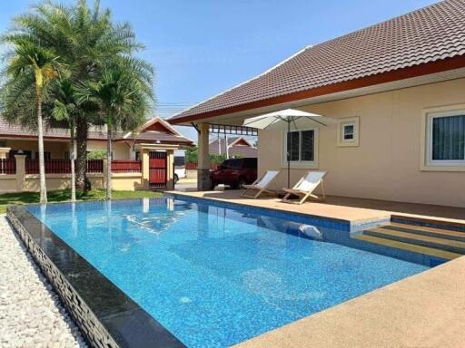 Private swimming pool area with lounge chairs and a tropical garden in a residential property