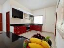 Modern kitchen with red cabinets, granite countertops, and dark flooring