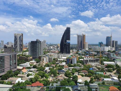 Cityscape view showcasing various buildings under a blue sky with clouds