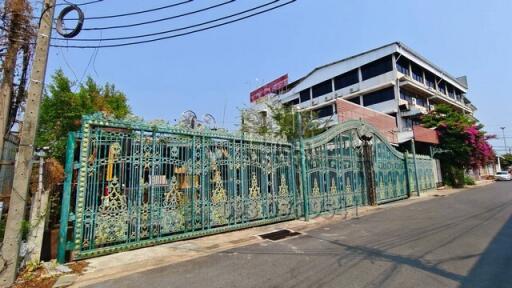 Exterior view of a multi-story building with decorative metal gate