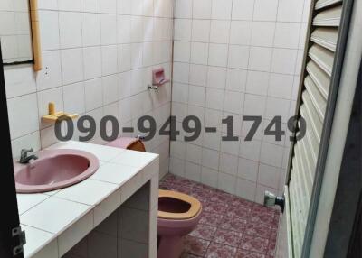 Compact bathroom with pink sink and toilet