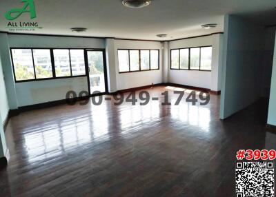 Spacious and well-lit empty living room with hardwood flooring