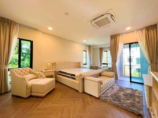 Spacious and well-lit master bedroom with modern furniture and balcony access