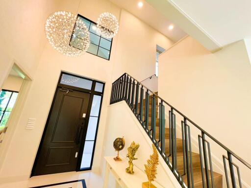 Modern entryway with chandelier and staircase