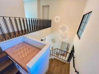 Modern staircase with chandelier and hardwood floors in a contemporary home