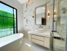 Modern bathroom with marble walls, freestanding bathtub, and greenery