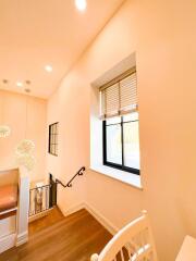 Bright Staircase Area with Wood Flooring and Window