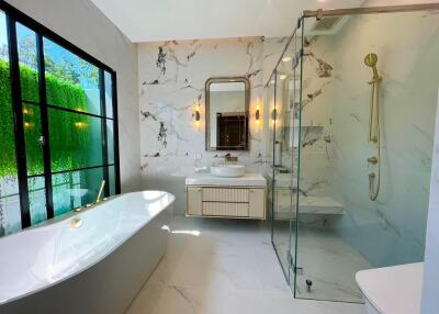 Modern bathroom with freestanding bathtub, shower, and marble finishes