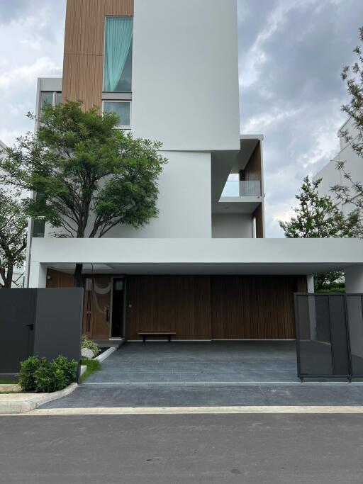 Modern multi-story residential building with a large entrance and wooden accents