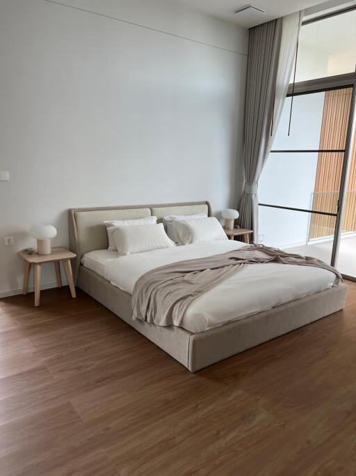 Modern bedroom with large bed and wooden flooring