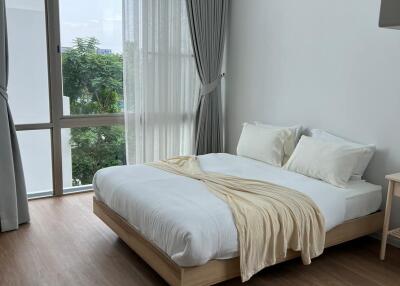 Bright and airy bedroom with large window and wooden floor