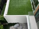 Bird's eye view of a modern home's outdoor area featuring a manicured lawn with decorative stones and garden path