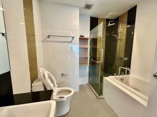 Modern bathroom with white fixtures and mosaic tile details