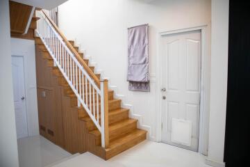 Bright entrance space with wooden staircase and white walls