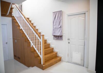 Bright entrance space with wooden staircase and white walls