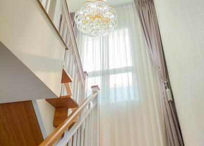 Elegant staircase with chandelier and large window