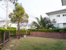 Spacious backyard garden with green lawn and walking path in residential neighborhood
