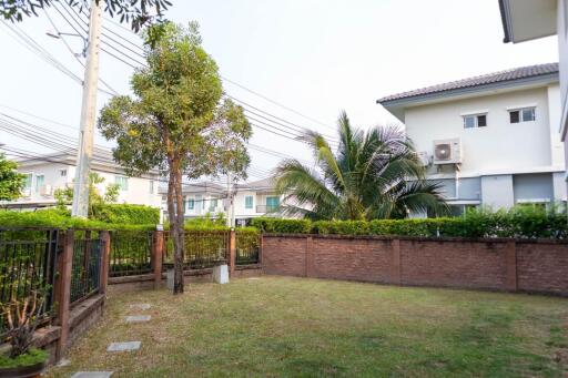 Spacious backyard garden with green lawn and walking path in residential neighborhood