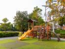 Modern children's playground set in a well-maintained grassy area with safety flooring