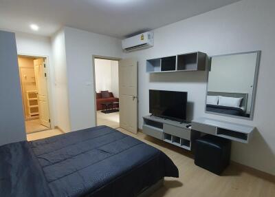 Modern bedroom with en-suite bathroom, air conditioning, and mounted television