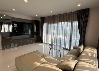 Modern and spacious living room with large sofa and flat-screen TV