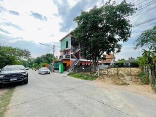 Street view of a two-story house with a green facade