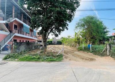 Street view of a building with adjacent vacant land and greenery