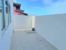 Compact rooftop terrace with surrounding walls under a clear sky