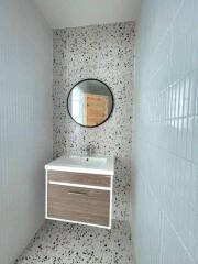 Modern bathroom with terrazzo flooring and wall-mounted sink