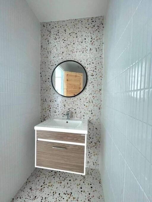 Modern bathroom with terrazzo flooring and wall-mounted sink