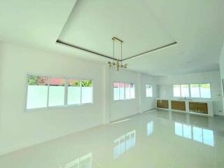 Spacious and well-lit living room with glossy floor tiles