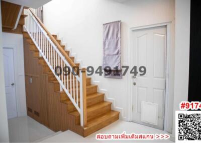 Wooden stairway and white door in a modern home entryway