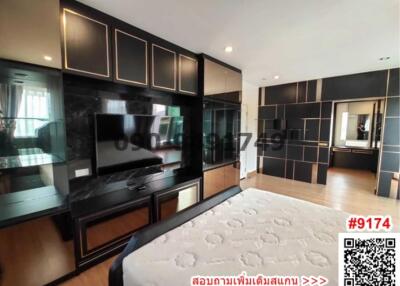 Modern bedroom interior with large bed and entertainment unit
