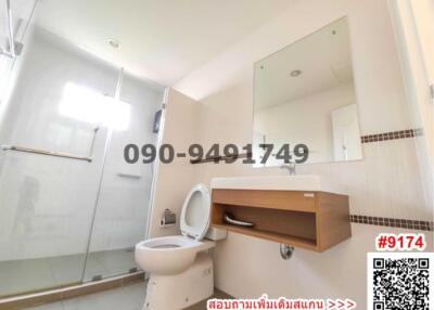 Modern bathroom with a toilet, sink, and mirror