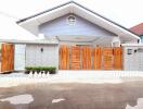 Spacious single-family home with wooden gate and stone wall facade