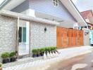 Modern single-story residential home with stone wall facade and wooden gate