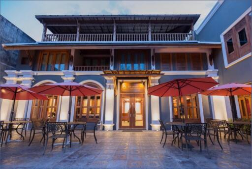 Elegant historical building facade at dusk with outdoor seating