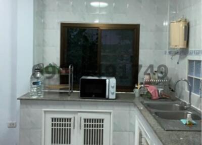 Compact fully tiled kitchen with modern appliances and ample cabinet space